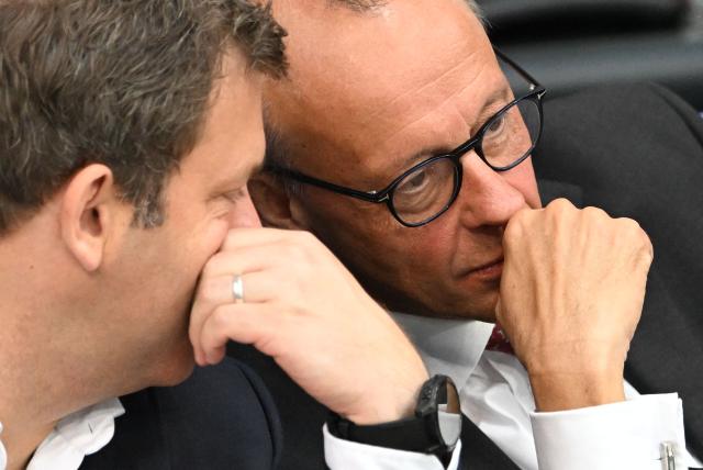 German Chancellor Friedrich Merz (R) and German Finance Minister and Vice Chancellor Lars Klingbeil chat while seated at a session of the Bundestag (lower house of parliament) during a general debate on budget, in Berlin on September 17, 2025. (Photo by RALF HIRSCHBERGER / AFP)