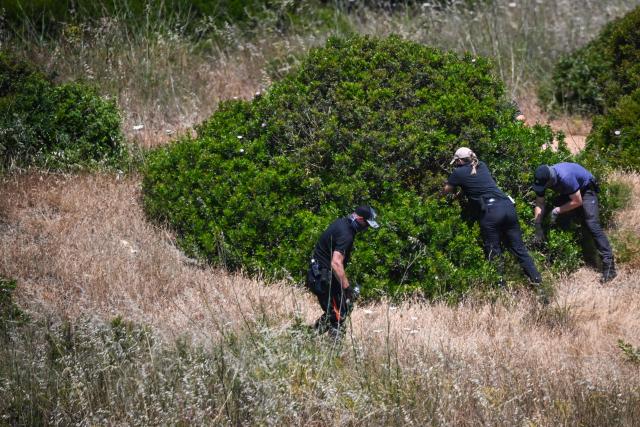 (FILES) Police investigators look in bushes during their investigation into the disappearance of Madeleine (or Maddie) McCann at Atalaia, Lagos, in Algarve on June 5, 2025. Christian B is accused of three counts of rape and two counts of child sex abuse allegedly committed in Portugal between 2000 and 2017. The charges are unrelated to the Madeleine McCann case, in which Christian B was sensationally revealed as a suspect in 2020. The man is already behind bars in Germany for raping a 72-year-old American tourist in 2005 in Praia da Luz, the same Portuguese seaside resort where Madeleine McCann, often referred to as Maddie, went missing two years later. (Photo by Patricia DE MELO MOREIRA / AFP)