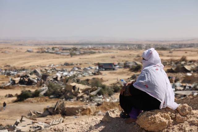 A Bedouin woman sits on a the ground in an area overlooking housing structures demolished by Israeli forces in the unrecognized village of as-Sir in the Negev desert in southern Israel on September 17, 2025. Israeli media said Bedouins protestered on September 17 against the demolition of tens of Arab residential structures deemed illegally built by the Israeli land authority in the northern Negev, south of Beersheva. (Photo by AHMAD GHARABLI / AFP)