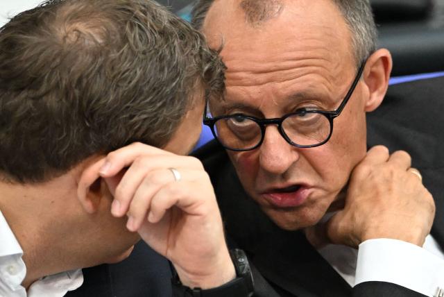 German Chancellor Friedrich Merz (R) and German Finance Minister and Vice Chancellor Lars Klingbeil chat while seated at a session of the Bundestag (lower house of parliament) during a general debate on budget, in Berlin on September 17, 2025. (Photo by RALF HIRSCHBERGER / AFP)