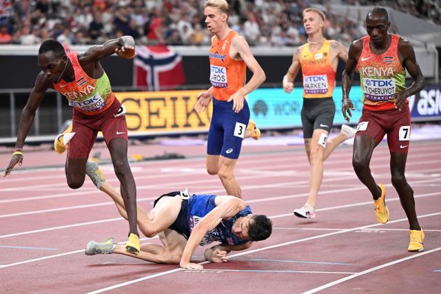 Britain's athlete Jake Wightman crashes as he crosses the finish line to win second place in the men's 1500m final during the World Athletics Championships in Tokyo on September 17, 2025. (Photo by Kirill KUDRYAVTSEV / AFP)