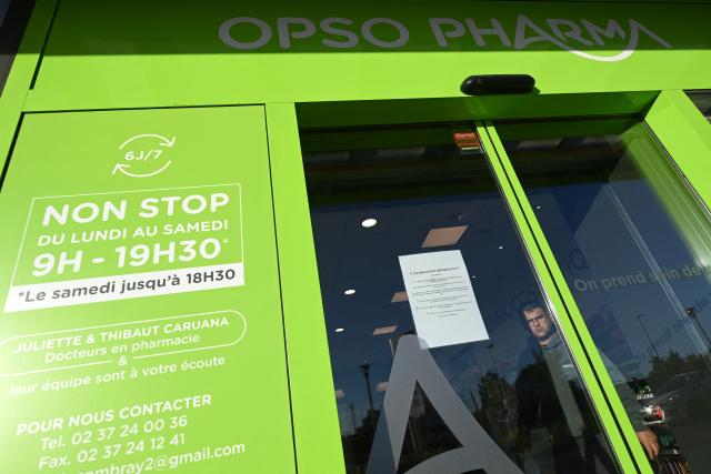 A person leaves a drugstore/pharmacy, in Illiers-Combray, western France, on September 17, 2025 on the eve of a national day of blockade. Pharmacies will also join forces on September 18, 2025: about nine out of ten will keep their shutters down to protest the reduction of commercial discounts on generics, a measure aimed at reducing health expenses but deemed catastrophic by the profession. (Photo by JEAN-FRANCOIS MONIER / AFP)