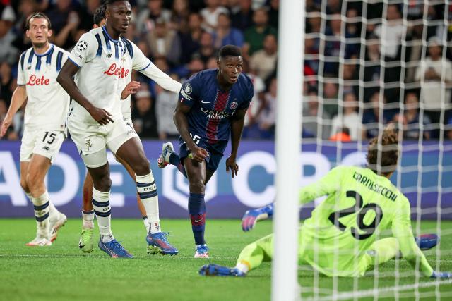 Paris Saint-Germain's Portuguese defender #25 Nuno Mendes (C) watches as he scores PSG's third goal during the UEFA Champions League first round day 1 football match between Paris Saint-Germain (FRA) and Atalanta (ITA) at the Parc des Princes stadium in Paris on September 17, 2025. (Photo by Anne-Christine POUJOULAT / AFP)