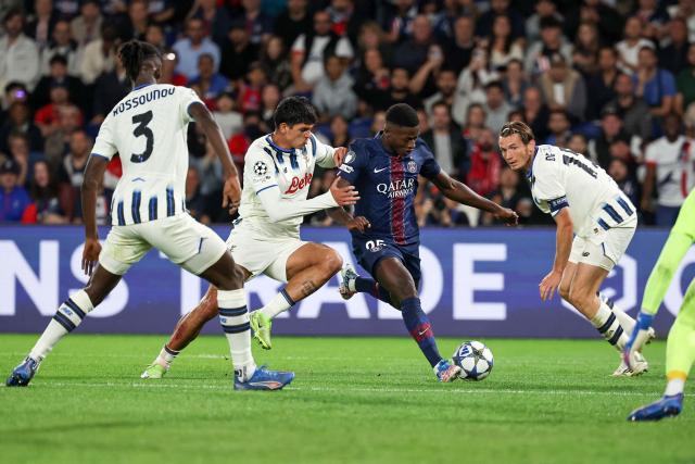Paris Saint-Germain's Portuguese defender #25 Nuno Mendes (CR) shoots to score PSG's third goal during the UEFA Champions League first round day 1 football match between Paris Saint-Germain (FRA) and Atalanta (ITA) at the Parc des Princes stadium in Paris on September 17, 2025. (Photo by Anne-Christine POUJOULAT / AFP)