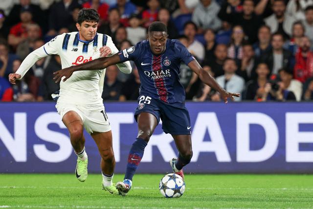 Paris Saint-Germain's Portuguese defender #25 Nuno Mendes (R) runs with the ball past Atalanta's Italian defender #16 Raoul Bellanova (L) to score PSG's third goal during the UEFA Champions League first round day 1 football match between Paris Saint-Germain (FRA) and Atalanta (ITA) at the Parc des Princes stadium in Paris on September 17, 2025. (Photo by Anne-Christine POUJOULAT / AFP)