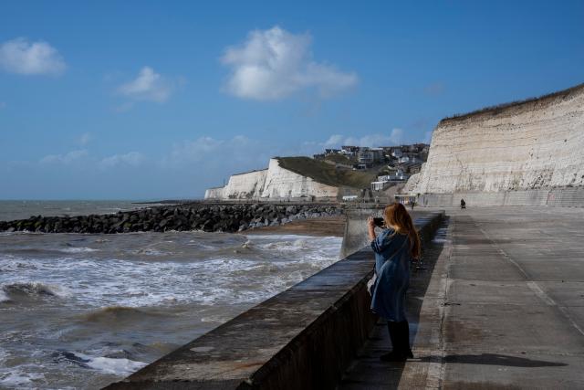 A person takes pictures of the waves at Saltdean Cliffs in Brighton, on the south coast of England on August 31, 2025. (Photo by CARLOS JASSO / AFP)