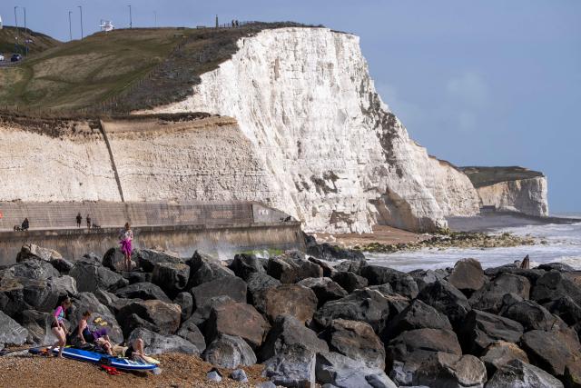 People relax on the beach at Saltdean Cliffs in Brighton, on the south coast of England on August 31, 2025. (Photo by CARLOS JASSO / AFP)
