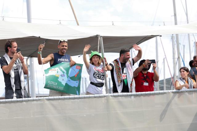 Swedish climate activist Greta Thunberg (3L) and activists wave as their boat, part of a civilian flotilla aiming at breaking the Israeli blockade of the Gaza Strip leaves the port of Barcelona, on August 31, 2025. A flotilla carrying humanitarian aid and activists is due to leave from Barcelona on August 31, 2025 to try to "break the illegal siege of Gaza", organisers said. The flotilla is expected to arrive at the war-ravaged coastal enclave in mid-September. (Photo by Lluis GENE / AFP)