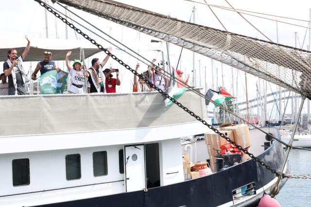 Swedish climate activist Greta Thunberg (3L) and activists wave as their boat, part of a civilian flotilla aiming at breaking the Israeli blockade of the Gaza Strip leaves the port of Barcelona, on August 31, 2025. A flotilla carrying humanitarian aid and activists is due to leave from Barcelona on August 31, 2025 to try to "break the illegal siege of Gaza", organisers said. The flotilla is expected to arrive at the war-ravaged coastal enclave in mid-September. (Photo by Lluis GENE / AFP)
