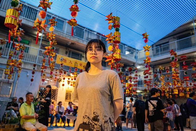 Janne Tsui, a resident at the Wah Fu Estate poses for a photograph during an interview with AFP on the occasion of the Hungry Ghost or the Yu Lan festival in Hong Kong on August 31, 2025. Eyes glowing red, the towering "ghost king" presided over the atrium of a Hong Kong housing block on August 31, as residents performed age-old rituals -- a scene that may become history as redevelopment looms. (Photo by Leung Man Hei / AFP)
