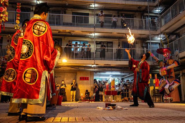 Taoist priests perform the 'Breaking the Hell's Gate' ritual during the Hungry Ghost or the Yu Lan festival at the Wah Fu Estate in Hong Kong on August 31, 2025. Eyes glowing red, the towering "ghost king" presided over the atrium of a Hong Kong housing block on August 31, as residents performed age-old rituals -- a scene that may become history as redevelopment looms. (Photo by Leung Man Hei / AFP)