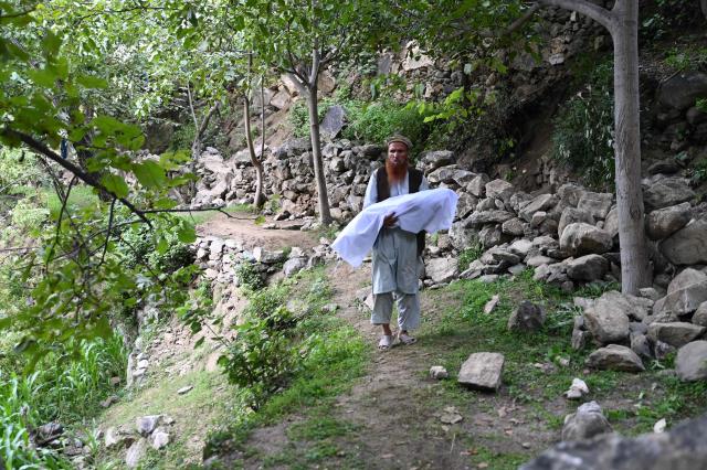 EDITORS NOTE: Graphic content / Afghan man carries a dead body of a boy covered in a shroud following earthquakes in the Mazar Dara village of Nurgal, a district of the Kunar Province, in Eastern Afghanistan, on September 1, 2025. More than 800 people have died and over 2,700 were injured from August 31 night to September 1, 2025, in eastern Afghanistan after a 6-magnitude earthquake, followed by at least five aftershocks felt hundreds of kilometers away. (Photo by Wakil Kohsar / AFP)