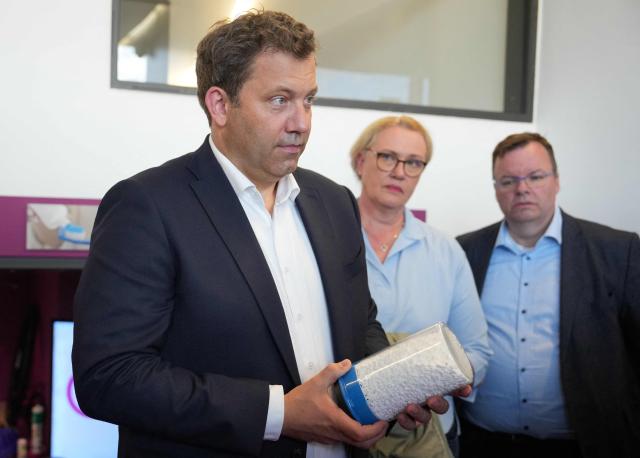 German Finance Minister and Vice Chancellor Lars Klingbeil holds a glass with silica during a visit of chemical company Evonik in Wesseling, on September 1, 2025. (Photo by Pau Barrena / AFP)