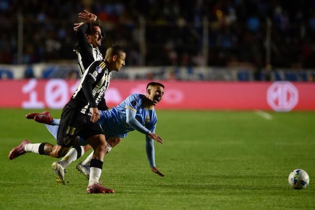 Atletico Mineiro's defender #13 Guilherme Arana (C) and Bolivar's midfielder #14 Robson Matheus (R) fight for the ball during the Copa Sudamericana quarterfinal first leg football match between Bolivia's Bolivar and Brazil's Atletico Mineiro at the Armando Siles Stadium in La Paz on September 17, 2025. (Photo by Jorge BERNAL / AFP)