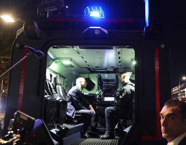France's Minister of the Interior Bruno Retailleau (L) speaks with a police officer inside a Centaur vehicle at Porte d'Orléans in Paris on September 18, 2025, prior to a day of nationwide strikes and protests called by unions over France's national budget. France is bracing for a day of nationwide protests on September 18, 2025, with a source close to the authorities saying some 800,000 people are expected to take to the streets. In a rare show of unity, trade unions have urged French people to strike in protest at the authorities' "horror show" draft budget designed to reduce France's ballooning debt. (Photo by Ludovic MARIN / AFP)