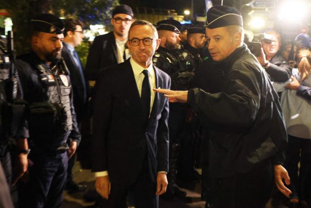 France's Minister of the Interior Bruno Retailleau (C) listens to a police officer at Porte d'Orléans in Paris on September 18, 2025, prior to a day of nationwide strikes and protests called by unions over France's national budget. France is bracing for a day of nationwide protests on September 18, 2025, with a source close to the authorities saying some 800,000 people are expected to take to the streets. In a rare show of unity, trade unions have urged French people to strike in protest at the authorities' "horror show" draft budget designed to reduce France's ballooning debt. (Photo by Ludovic MARIN / AFP)