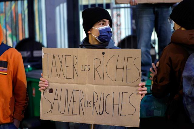 A student holds a placard while blocking the entrance to Maurice Ravel school in Paris, on September 18, 2025, during a day of nationwide strikes and protests called by unions over France's national budget. France is bracing for a day of nationwide protests on September 18, 2025, with a source close to the authorities saying some 800,000 people are expected to take to the streets. In a rare show of unity, trade unions have urged French people to strike in protest at the authorities' "horror show" draft budget designed to reduce France's ballooning debt. (Photo by GEOFFROY VAN DER HASSELT / AFP)