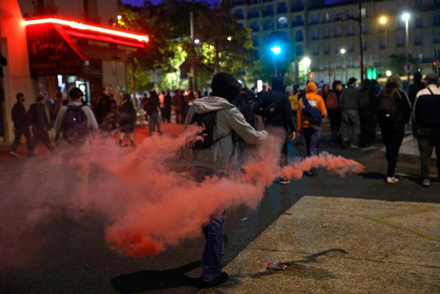 A demonstrator throws a tear gas canister as they clash with the Police in Paris, on September 18, 2025, during a day of nationwide strikes and protests called by unions over France's national budget. France is bracing for a day of nationwide protests on September 18, 2025, with a source close to the authorities saying some 800,000 people are expected to take to the streets. In a rare show of unity, trade unions have urged French people to strike in protest at the authorities' "horror show" draft budget designed to reduce France's ballooning debt. (Photo by GEOFFROY VAN DER HASSELT / AFP)