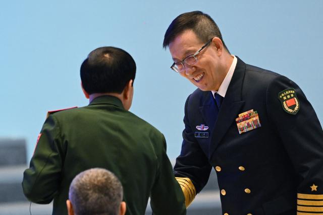 China's Defence Minister Dong Jun (R) shakes hands with Vietnam’s Defence Minister Phan Van Giang after the opening ceremony of the Xiangshan Forum at the Beijing International Convention Center in Beijing on September 18, 2025. (Photo by GREG BAKER / AFP)