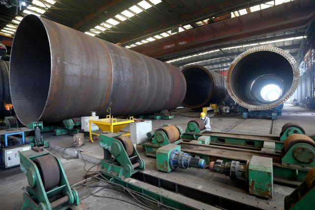A worker makes part of wind turbines at a factory in Lianyungang, in China’s eastern Jiangsu province on September 18, 2025. (Photo by AFP) / China OUT