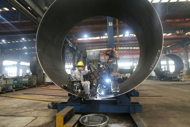 A worker makes part of wind turbines at a factory in Lianyungang, in China’s eastern Jiangsu province on September 18, 2025. (Photo by AFP) / China OUT