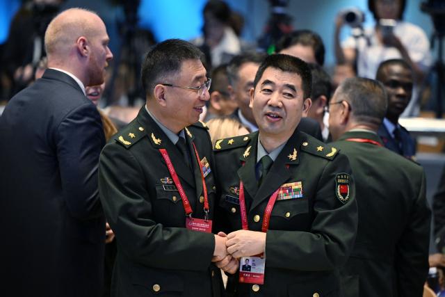 Chinese military delegates chat before the opening ceremony of the Xiangshan Forum at the Beijing International Convention Center in Beijing on September 18, 2025. (Photo by GREG BAKER / AFP)
