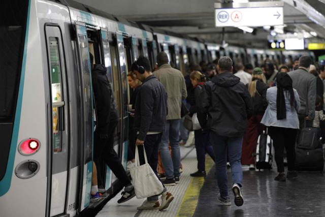 Commuters board a train of the line 9 at the Nation station in Paris, on September 18, 2025, as the number of trains is reduced, except during peak hours, on all non-automatic subway lines due to a a day of nationwide strikes and protests called by unions over France's national budget. France is bracing for a day of nationwide protests on September 18, 2025, with a source close to the authorities saying some 800,000 people are expected to take to the streets. In a rare show of unity, trade unions have urged French people to strike in protest at the authorities' "horror show" draft budget designed to reduce France's ballooning debt. (Photo by GEOFFROY VAN DER HASSELT / AFP)
