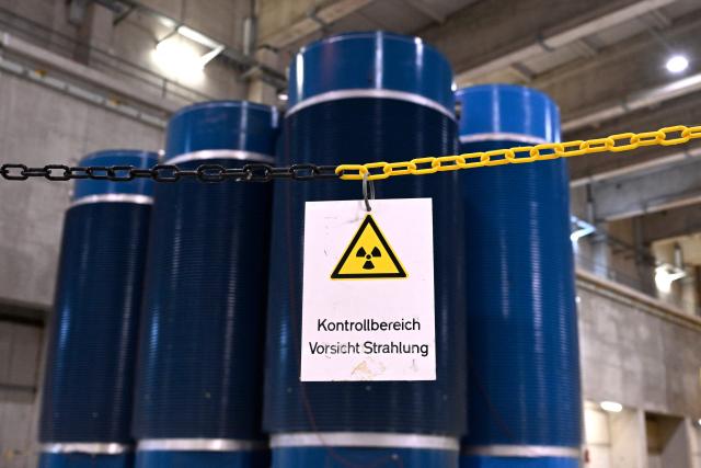 A photo shows a sign reading 'Restricted area  caution radiation' in front of Castor containers for highly radioactive fuel elements from the former Gundremmingen and Neckarwestheim nuclear power plants at the Ahaus interim storage facility in Ahaus, western Germany on September 18, 2025. On August 26, 2025, the Federal Office for the Safety of Nuclear Waste Disposal (BASE) approved the controversial transport of nuclear waste from Juelich in the Rhineland to the interim storage facility in Ahaus in the Muensterland region. (Photo by Ina FASSBENDER / AFP)
