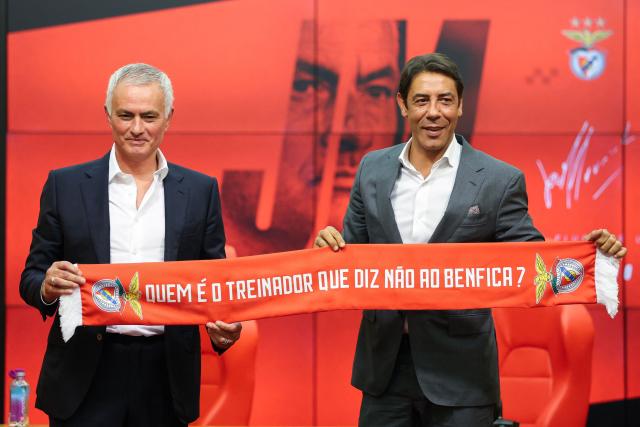 Portuguese coach Jose Mourinho (L) holds up scarf together with Benfica president Rui Costa which reads "Who is the coach who says no to Benfica" during a press conference for his official presentation as new Benfica coach at the Benfica Campus training center in Seixal, on the outskirts of Lisbon, on September 18, 2025. Benfica sacked Portuguese coach Bruno Lage following their defeat to Qarabag on September 16, 2025 evening in the Champions League, and contacted Jose Mourinho the next day to hire him. (Photo by PATRICIA DE MELO MOREIRA / AFP)