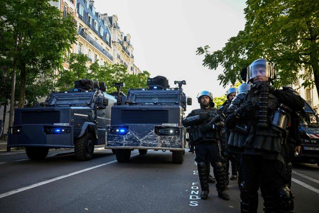 French police officer stand next to Centaure multipurpose intervention vehicles (VIPG) in the Place de la Nation in Paris, on September 18, 2025, during a day of nationwide strikes and protests called by unions over France's national budget. France is bracing for a day of nationwide protests on September 18, 2025, with a source close to the authorities saying some 800,000 people are expected to take to the streets. In a rare show of unity, trade unions have urged French people to strike in protest at the authorities' "horror show" draft budget designed to reduce France's ballooning debt. (Photo by JULIEN DE ROSA / AFP)
