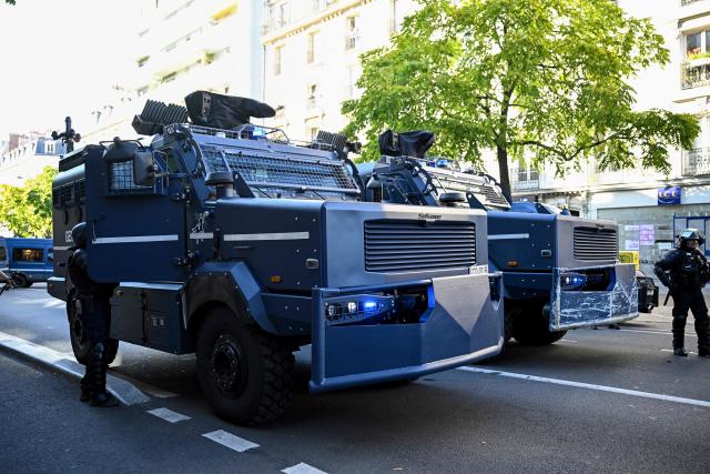 French police officers stand next to Centaure multipurpose intervention vehicles (VIPG) in Paris, on September 18, 2025, during a day of nationwide strikes and protests called by unions over France's national budget. France is bracing for a day of nationwide protests on September 18, 2025, with a source close to the authorities saying some 800,000 people are expected to take to the streets. In a rare show of unity, trade unions have urged French people to strike in protest at the authorities' "horror show" draft budget designed to reduce France's ballooning debt. (Photo by JULIEN DE ROSA / AFP)