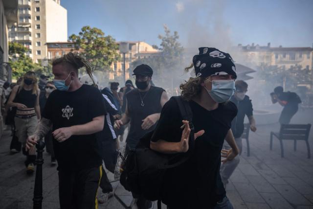 Demonstrators run away from tear gas after clashing with police during a protest entitled 'Bloquons Tout' in Toulouse, southwestern France, on September 18, 2025, during a day of nationwide strikes and protests called by unions over France's national budget. France is bracing for a day of nationwide protests on September 18, 2025, with a source close to the authorities saying some 800,000 people are expected to take to the streets. In a rare show of unity, trade unions have urged French people to strike in protest at the authorities' "horror show" draft budget designed to reduce France's ballooning debt. (Photo by Ed JONES / AFP)