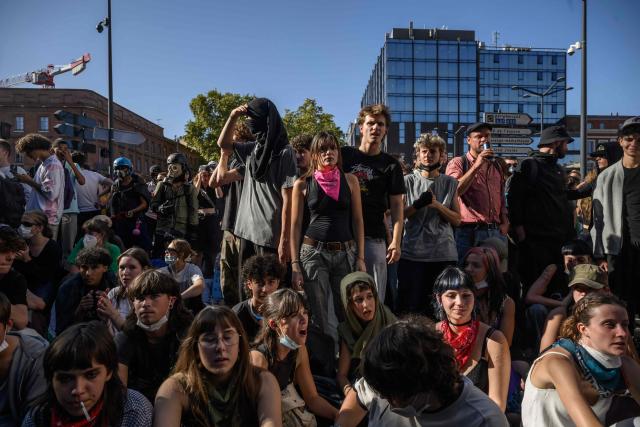 Demonstrators shout slogans as they sit before a police cordon during a protest entitled 'Bloquons Tout' in Toulouse, southwestern France, on September 18, 2025, during a day of nationwide strikes and protests called by unions over France's national budget. France is bracing for a day of nationwide protests on September 18, 2025, with a source close to the authorities saying some 800,000 people are expected to take to the streets. In a rare show of unity, trade unions have urged French people to strike in protest at the authorities' "horror show" draft budget designed to reduce France's ballooning debt. (Photo by Ed JONES / AFP)