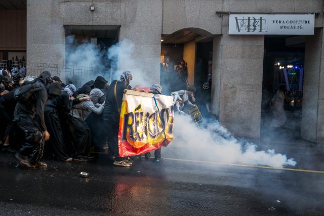 Protesters face tear gas during an unauthorized pro-Palestinian demonstration in Lausanne on September 18, 2025. (Photo by Fabrice COFFRINI / AFP)