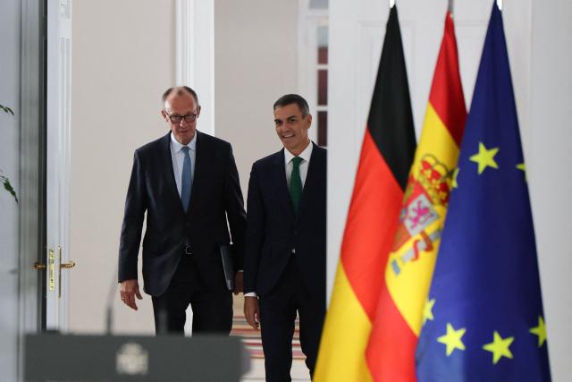 Spain's Prime Minister Pedro Sanchez (R) arrives next to German Chancellor Friedrich Merz for a joint press conference at the Moncloa Palace in Madrid on September 18, 2025. (Photo by Thomas COEX / AFP)