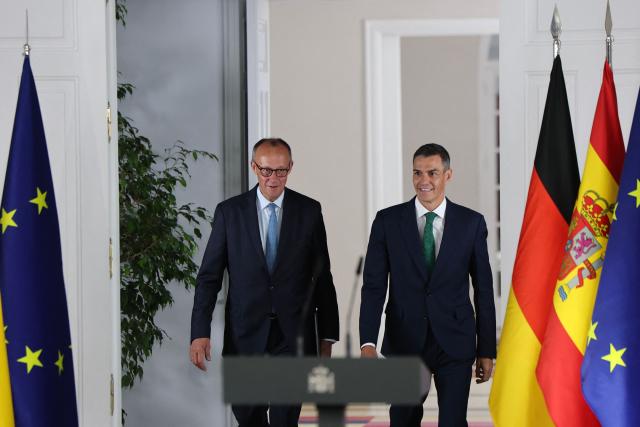 Spain's Prime Minister Pedro Sanchez (R) arrives next to German Chancellor Friedrich Merz for a joint press conference at the Moncloa Palace in Madrid on September 18, 2025. (Photo by Thomas COEX / AFP)