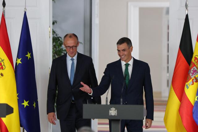 Spain's Prime Minister Pedro Sanchez (R) arrives next to German Chancellor Friedrich Merz for a joint press conference at the Moncloa Palace in Madrid on September 18, 2025. (Photo by Thomas COEX / AFP)