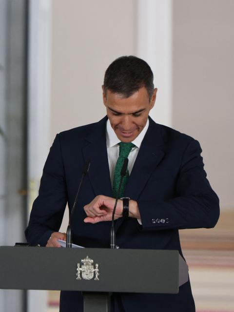 Spain's Prime Minister Pedro Sanchez checks his watch as he arrives  for a joint press conference with German Chancellor Friedrich Merz at the Moncloa Palace in Madrid on September 18, 2025. (Photo by Thomas COEX / AFP)