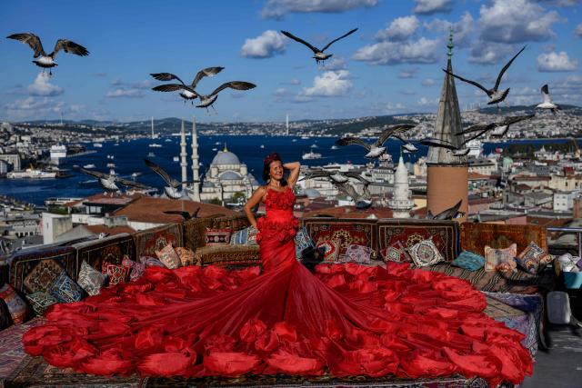 TOPSHOT - A tourist looks out towards the Bosphorus as she poses for a photograph in an open-air studio terrace, in Istanbul on September 18, 2025. (Photo by Yasin AKGUL / AFP)