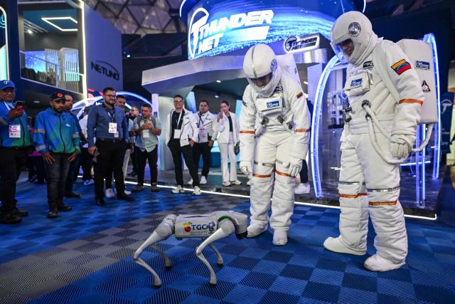 Two robots are presented at the communications and technology fair in Caracas on September 18, 2025. (Photo by Juan BARRETO / AFP)