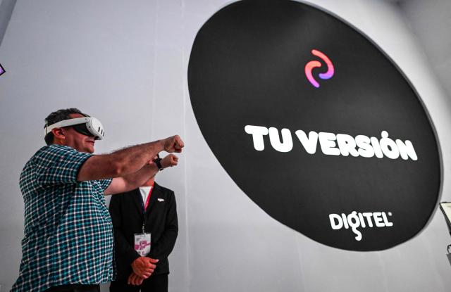 A man interacts using VR glasses during the communications and technology fair in Caracas on September 18, 2025. (Photo by Juan BARRETO / AFP)