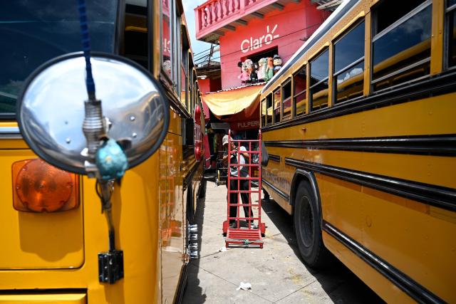 A man stands in front of a hand truck between buses at the Zona Belen market in Tegucigalpa on September 18, 2025. (Photo by Orlando SIERRA / AFP)