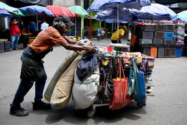 A man carries a cart at the Zona Belen market in Tegucigalpa on September 18, 2025. (Photo by Orlando SIERRA / AFP)