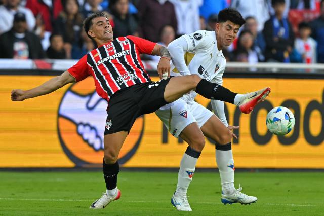 Sao Paulo's Argentine defender #13 Enzo Diaz (L) and Liga de Quito's Bolivian midfielder #15 Gabriel Villamil (R) fight for the ball during the Copa Libertadores quarterfinal first leg football match between Ecuador's Liga de Quito and Brazil's Sao Paulo at the Rodrigo Paz Delgado Stadium in Quito on September 18, 2025. (Photo by Rodrigo BUENDIA / AFP)