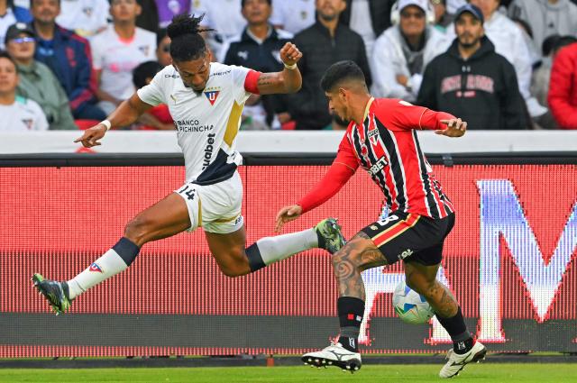 Liga de Quito's defender #14 Jose Quintero and Sao Paulo's Argentine defender #28 Alan Franco fight for the ball during the Copa Libertadores quarterfinal first leg football match between Ecuador's Liga de Quito and Brazil's Sao Paulo at the Rodrigo Paz Delgado Stadium in Quito on September 18, 2025. (Photo by Rodrigo BUENDIA / AFP)