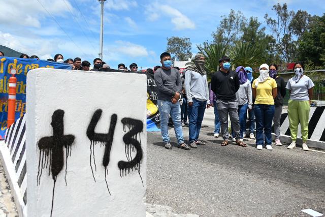 People take part in a protest over the 11th anniversary of the disappearance of 43 students from Ayotzinapa, on a toll road at the outskirts of Chilpancingo, Guerrero state, Mexico, on September 18, 2025. The case of the 43 students who disappeared from a rural school in Ayotzinapa in 2014 is one of the most serious human rights violations committed in Mexico, probably involving police officers, drug traffickers and military commanders, according to investigations. (Photo by Francisco ROBLES / AFP)