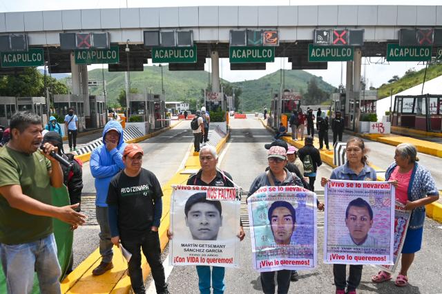 People take part in a protest over the 11th anniversary of the disappearance of 43 students from Ayotzinapa, on a toll road at the outskirts of Chilpancingo, Guerrero state, Mexico, on September 18, 2025. The case of the 43 students who disappeared from a rural school in Ayotzinapa in 2014 is one of the most serious human rights violations committed in Mexico, probably involving police officers, drug traffickers and military commanders, according to investigations. (Photo by Francisco ROBLES / AFP)