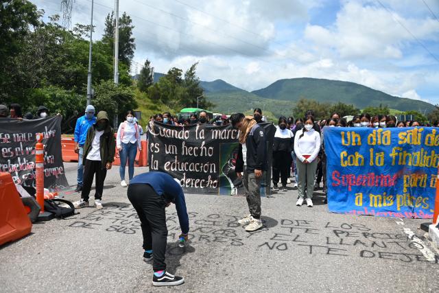 People take part in a protest over the 11th anniversary of the disappearance of 43 students from Ayotzinapa, on a toll road at the outskirts of Chilpancingo, Guerrero state, Mexico, on September 18, 2025. The case of the 43 students who disappeared from a rural school in Ayotzinapa in 2014 is one of the most serious human rights violations committed in Mexico, probably involving police officers, drug traffickers and military commanders, according to investigations. (Photo by Francisco ROBLES / AFP)