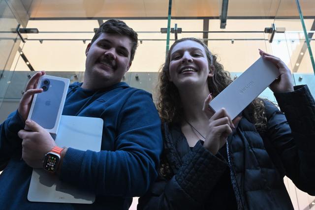 One of the first customers leaves the Apple Store with a pre-ordered iPhone 17 Pro and Apple Watch in Sydney on September 19, 2025. (Photo by Saeed KHAN / AFP)