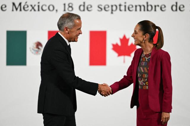 Canada's Prime Minister Mark Carney (L) and Mexico's President Claudia Sheinbaum (R) shake hands after a joint press conference at the National Palace in Mexico City on September 18, 2025. Mexico's President Claudia Sheinbaum and Canada's Prime Minister Mark Carney met in Mexico City as Trump pushes to renegotiate the USMCA North American trade pact in place since 2020. It replaced the NAFTA accord signed in the 1990s. (Photo by Yuri CORTEZ / AFP)